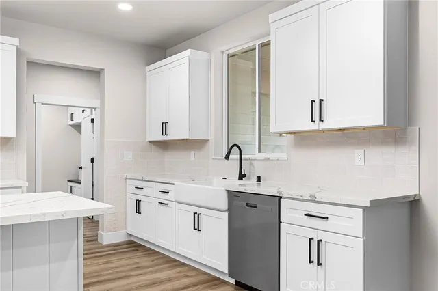 a kitchen with stainless steel appliances white cabinets sink and stove