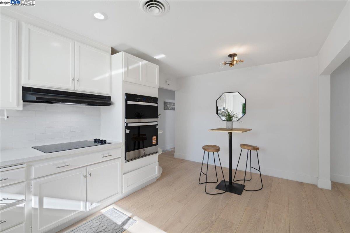 4023 Roland Drive Concord, CA 94521 - Photo 16 of 59 a kitchen with granite countertop a white cabinets and chandelier