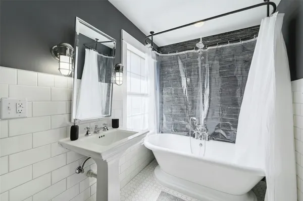 a bathroom with a sink mirror and a bathtub