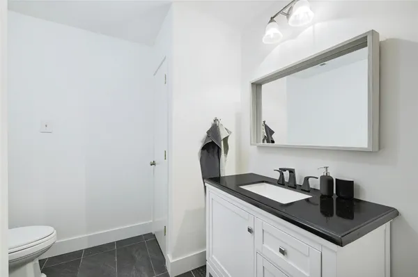 a bathroom with a sink toilet and mirror