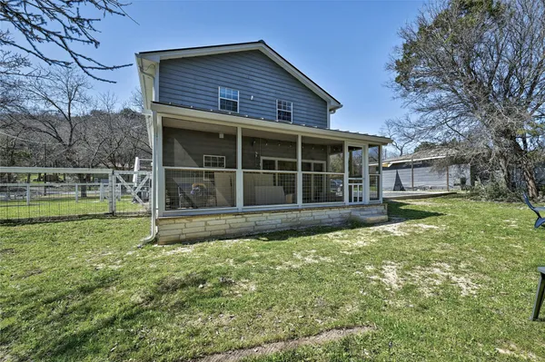 a view of a house with a yard and a large tree