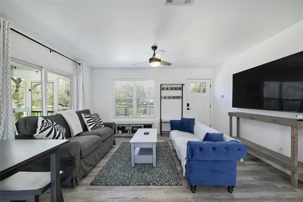 a living room with furniture a flat screen tv and a large window