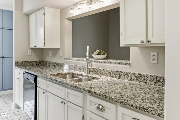 a kitchen with granite countertop a sink and cabinets