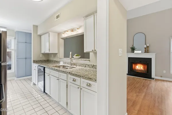 a kitchen with granite countertop a sink stove and refrigerator