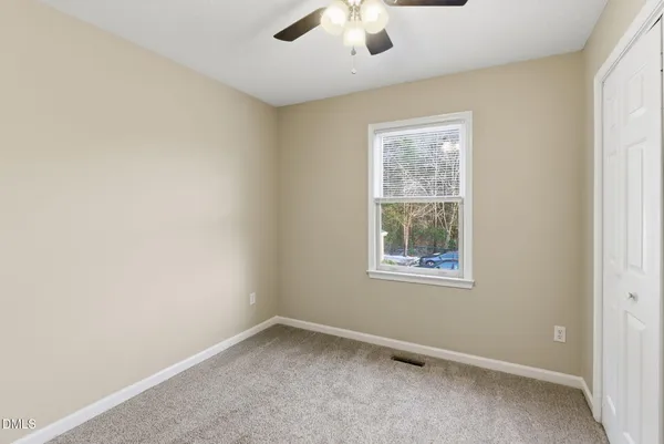 an empty room with windows and closet