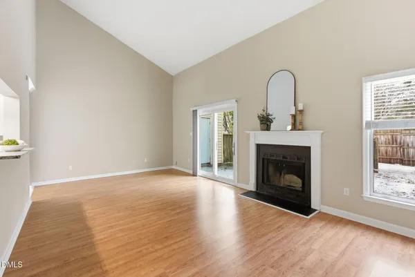 a view of empty room with wooden floor and fireplace
