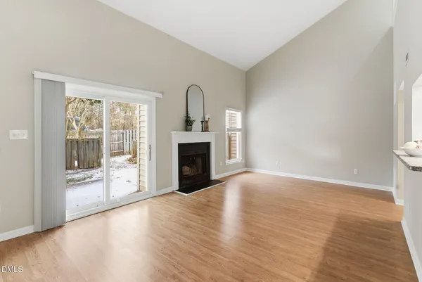a view of empty room with wooden floor and fireplace