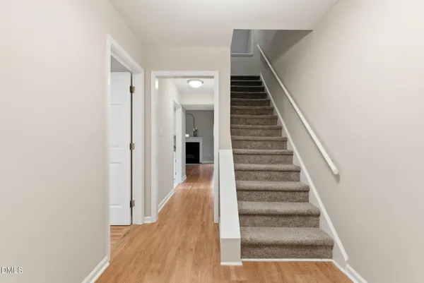 a view of a hallway with wooden floor and entryway
