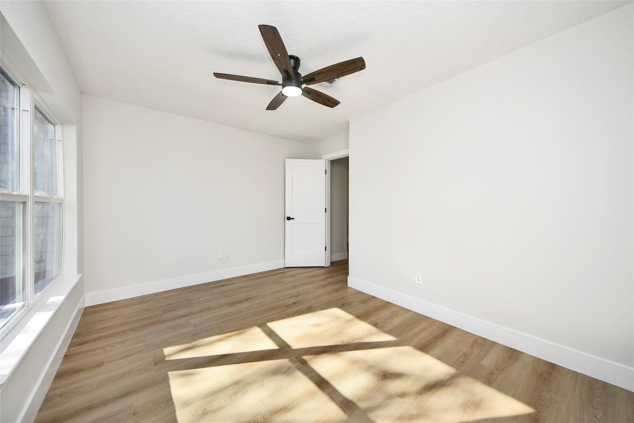 10223 Dude Road Houston, TX 77064 - Photo 32 of 44 a view of a big room with wooden floor a ceiling fan and windows