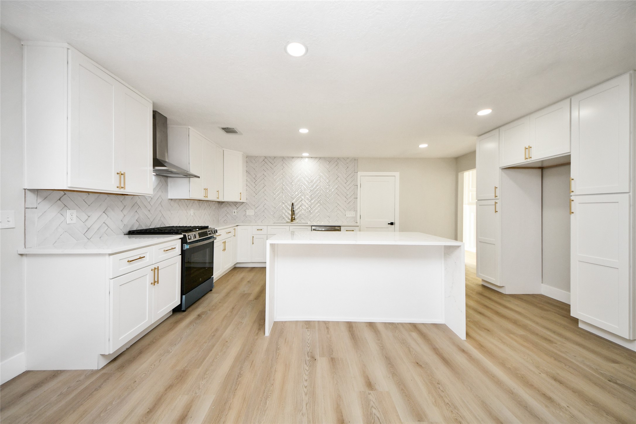 10223 Dude Road Houston, TX 77064 - Photo 10 of 44 a large kitchen with a white stove top oven and white cabinets