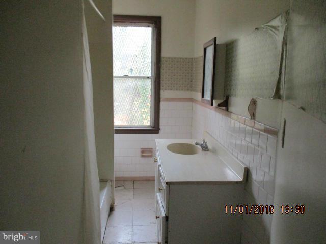 5218 Dogwood Road Gwynn Oak, MD 21207 - Photo 8 of 11 a bathroom with a sink and a mirror