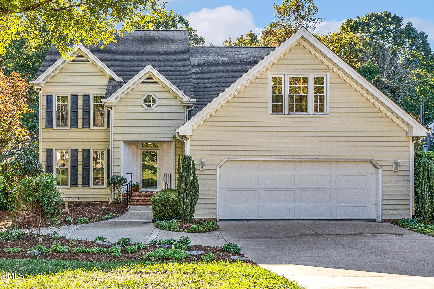 a view of a white house with large windows next to a yard