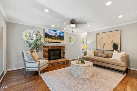 a living room with furniture kitchen view and a chandelier