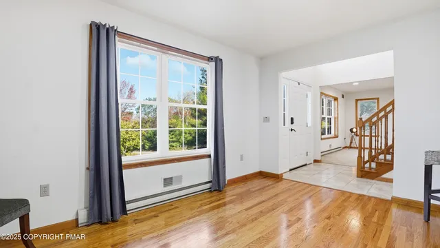 a view of a hallway with wooden floor and staircase
