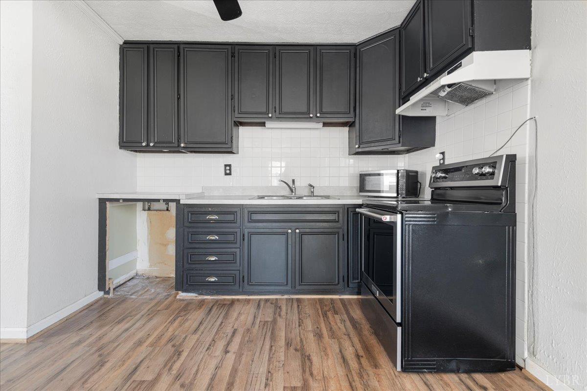 813 Doss Road Concord, VA 24538 - Photo 16 of 31 a kitchen with stainless steel appliances granite countertop a sink and cabinets with wooden floor