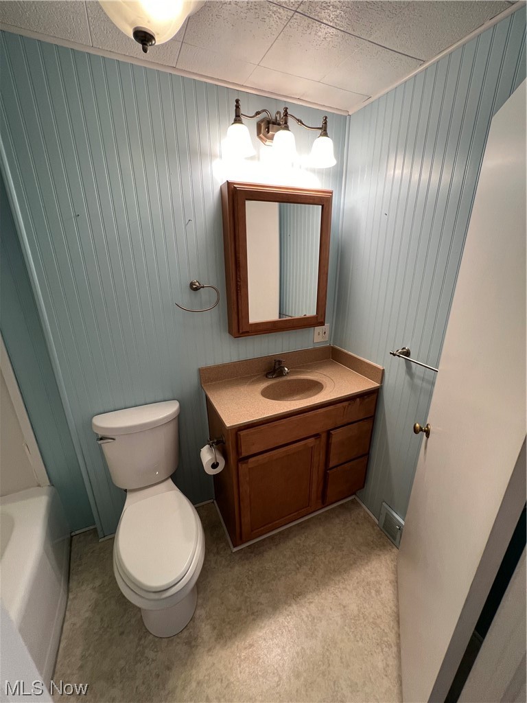 545 7th Street Struthers, OH 44471 - Photo 9 of 17 Full bathroom featuring toilet, oversized vanity, shower / tub combination, a drop ceiling, and wood walls