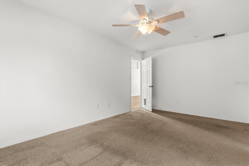 3374 Hamlet Loop Winter Park, FL 32792 - Photo 13 of 37 an empty room with a chandelier fan and windows