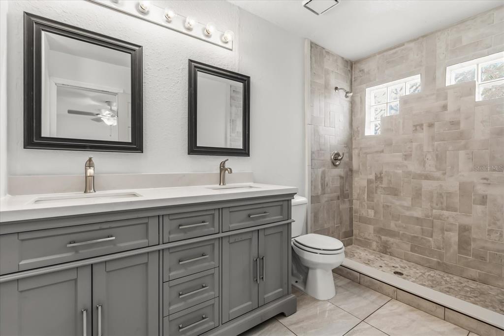 3374 Hamlet Loop Winter Park, FL 32792 - Photo 14 of 37 a bathroom with a double vanity sink toilet and shower