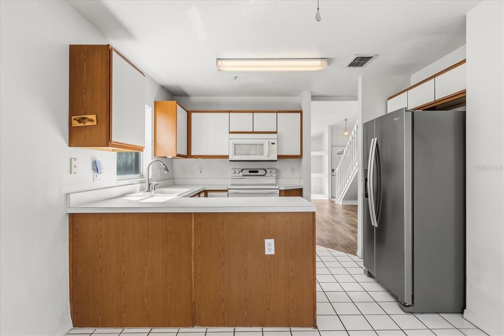 3374 Hamlet Loop Winter Park, FL 32792 - Photo 10 of 37 a kitchen with stainless steel appliances granite countertop a refrigerator a sink a stove and a refrigerator