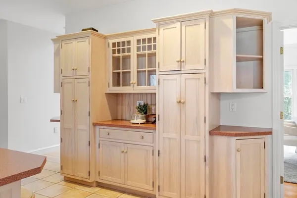 a view of cabinets with stainless steel appliances wooden floor and chair