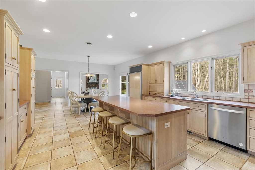 78 Cutters Ridge Road Carlisle, MA 01741 - Photo 14 of 42 a dining hall with stainless steel appliances granite countertop a stove a sink a dining table and chairs