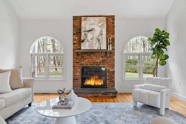 a living room with furniture a fireplace and a large window