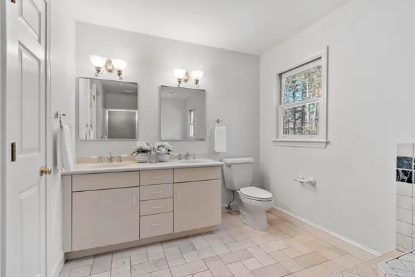 a bathroom with a toilet sink and mirror