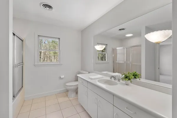 a bathroom with a granite countertop sink mirror and toilet