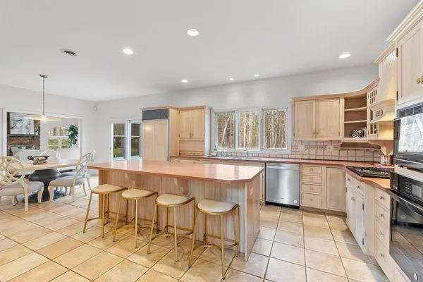 a large kitchen with lots of counter and chairs