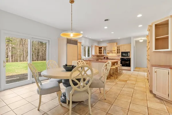 a view of a dining room and livingroom with furniture wooden floor a chandelier
