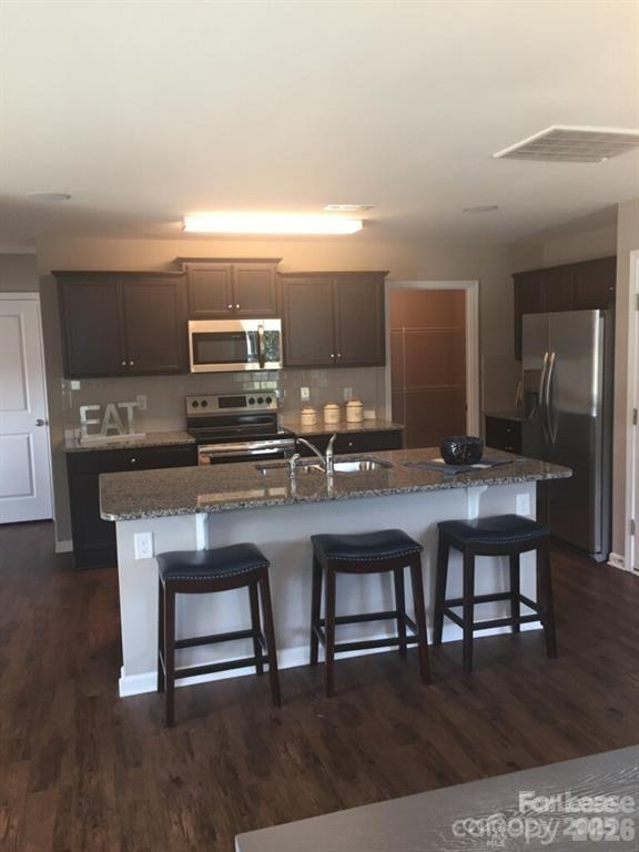 3973 BETHESDA Place Concord, NC 28025 - Photo 3 of 12 a kitchen with kitchen island a dining table and chairs