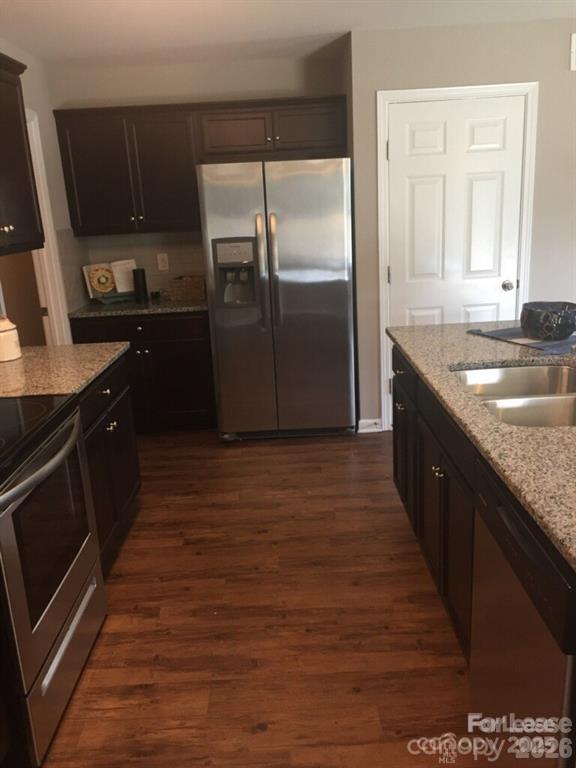3973 BETHESDA Place Concord, NC 28025 - Photo 4 of 12 a kitchen with kitchen island granite countertop a sink and a refrigerator