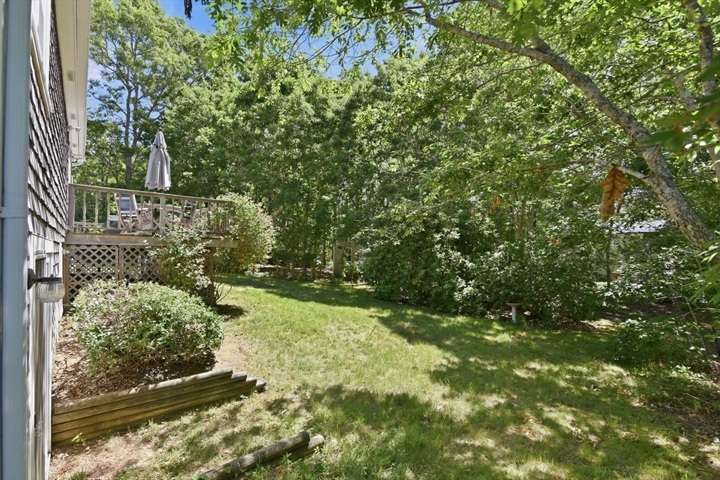 8 Emerald Way Sandwich, MA 02644 - Photo 33 of 36 a backyard of a house with lots of green space and garden