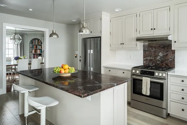 a kitchen with stainless steel appliances granite countertop a sink a stove and a refrigerator