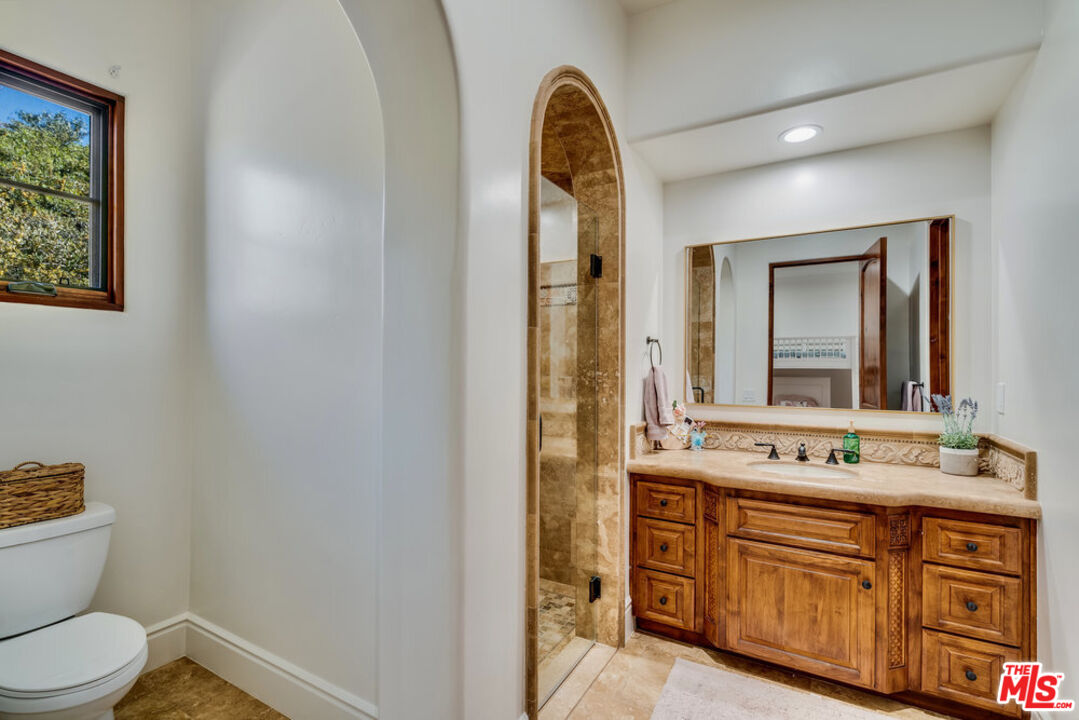 18000 Sunset Point Road Poway, CA 92064 - Photo 22 of 43 a bathroom with a double vanity sink a mirror and a toilet