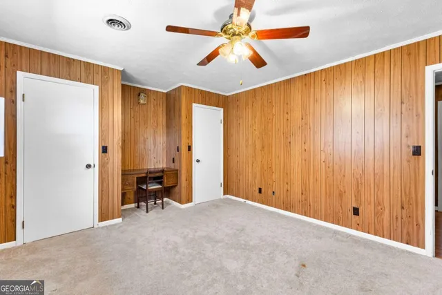 a view of a livingroom with a chandelier fan and a window