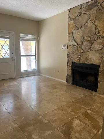 a view of empty room with wooden floor and fireplace
