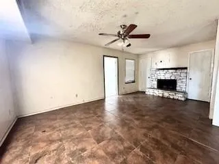 an empty room with windows and fireplace