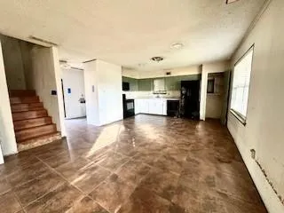 a view of a hallway view with wooden floor and a kitchen