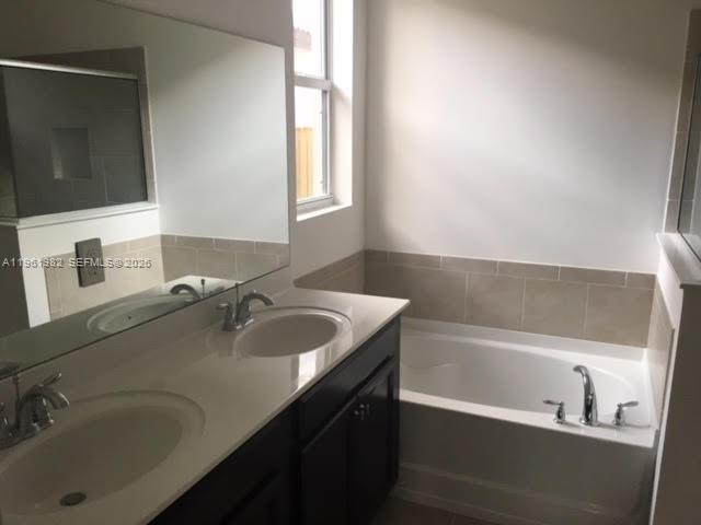 11842 Southwest 253rd Terrace Homestead, FL 33032 - Photo 11 of 15 a bathroom with a tub sink and mirror