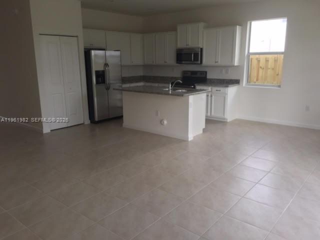 11842 Southwest 253rd Terrace Homestead, FL 33032 - Photo 2 of 15 a kitchen with stainless steel appliances a sink a stove a microwave a refrigerator a window and cabinets