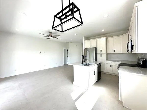 a large kitchen with cabinets a sink and appliances