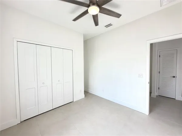 an empty room with chandelier fan