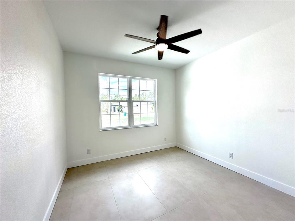 26129 Northern Cross Road Punta Gorda, FL 33983 - Photo 21 of 40 an empty room with ceiling fan and windows