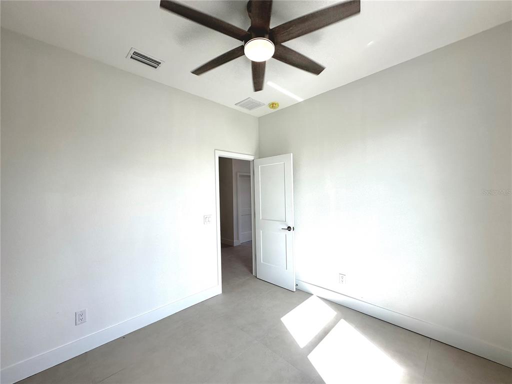 26129 Northern Cross Road Punta Gorda, FL 33983 - Photo 22 of 40 an empty room with a chandelier fan and a ceiling fan