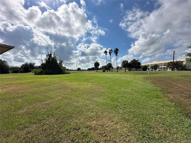 a view of a field with houses in the background