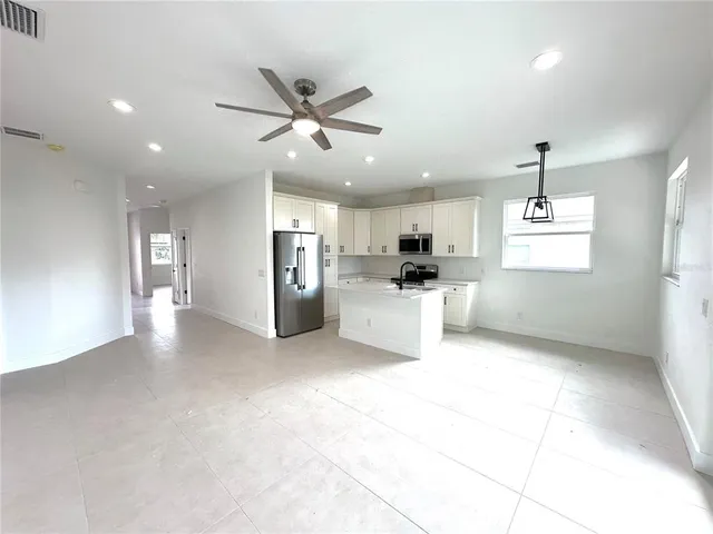 a view of a kitchen with refrigerator and windows
