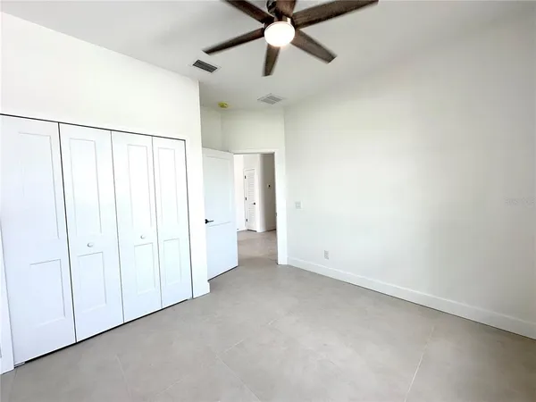 an empty room with chandelier fan