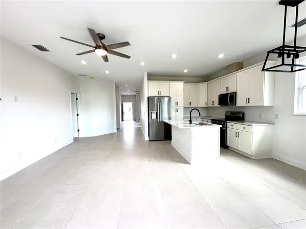 a view of kitchen with stainless steel appliances refrigerator oven microwave and cabinets