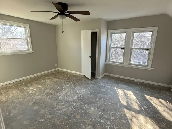 an empty room with windows and closet